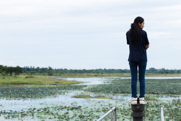 Young beautiful Asian girl standing on jetty