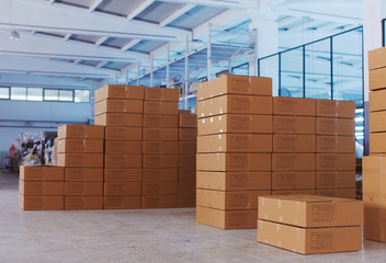 Boxes full of production with tags are prepared for cargo in beautiful bright small factory