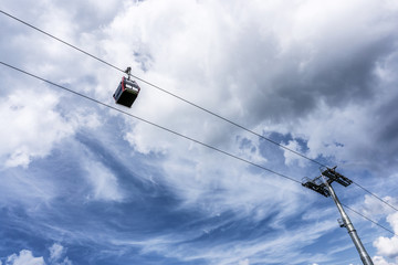 Einzelne Gondel einer Seilbahn vor bew&ouml;lktem Himmel