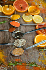 the fragrance of spices, red pepper, black pepper, mustard,sunflower seeds ,and orange slices of citrus fruits on dark wooden background of the table.