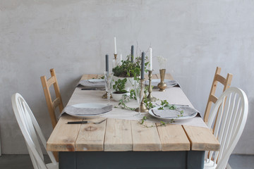 Served wooden table decorated with flowers and ivy