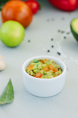 Traditional mexican avocado - vegetarian dip surrounded by its ingredients.