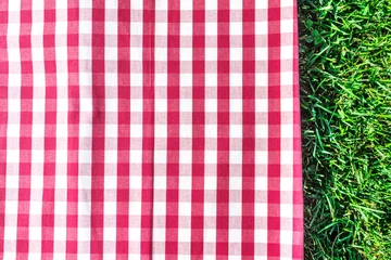 Fotobehang Picknick Rood gingangtafelkleed op groen gras met copyspace