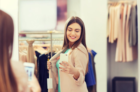 woman taking mirror selfie by smartphone at store