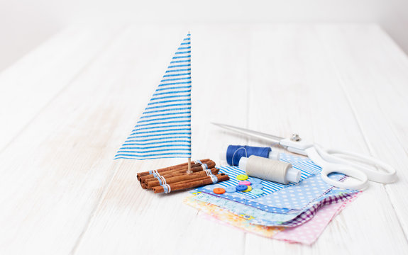 Ship toy and pieces of cloth with sewing accessories