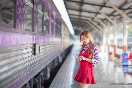 Women search location Journey by train on platform of railway station in thailand