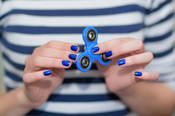 A girl is holding a popular toy fidget spinner in her hands. Stress relief. Anti stress and...
