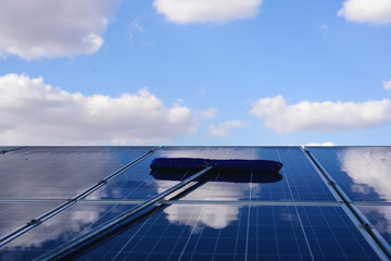 Workers or engineers are cleaning cleaning  photovoltaic panels in the Solar power plant ,Clean energy production idea, pure energy, solar energy