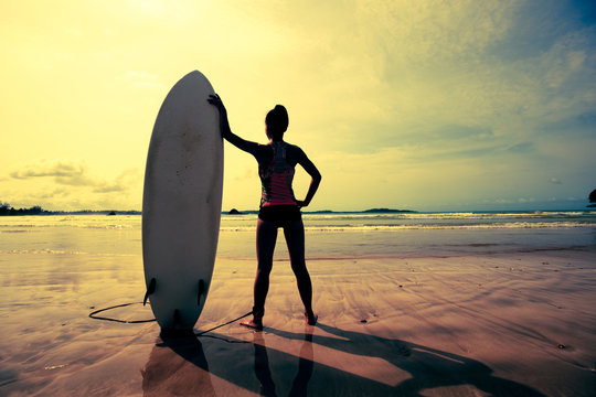 Young woman surfer with surfboard ready to surf