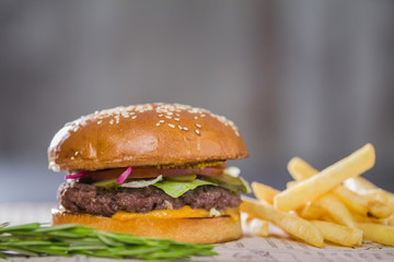 Big fresh appetizing burger with pepper and potatoes