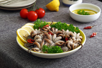 polpo o moscardini pesce crudo in piatto di ceramica sfondo tavolo di cucina
