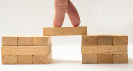 Wooden Building Blocks on white background with hand concept Bridge success