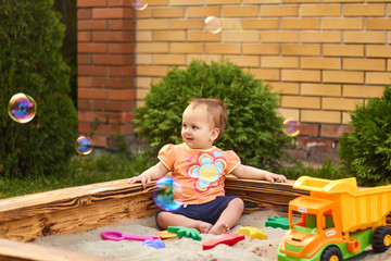 Beautiful baby playing in the sandbox