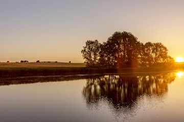 Fototapeta na wymiar Beautiful sunrise in the summer by the lake