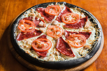 Delicious pizza with meat, cheese and mushrooms