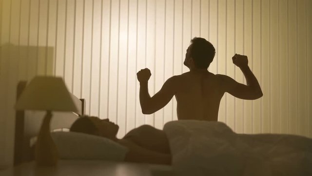 The man does exercise near the woman in the bed