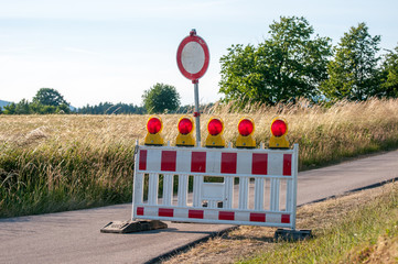 Red and white colored street barrier on empty road at night Closed Road at Darkness
