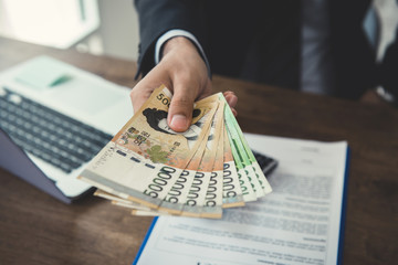 Businessman giving money, South Korean won banknotes