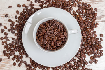 coffee cup with roasted coffee beans on wood table, with copy space
