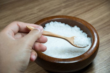 Fototapeta na wymiar Salt scoop with wooden spoon Salt in a wooden cup