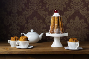 Still life with a festive cake and cupcakes in cups