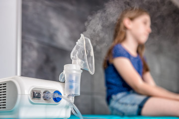 Little girl waiting for medical inhalation treatment with a nebulizer - obrazy, fototapety, plakaty