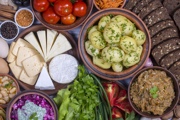 Assortment of cooked food and vegetables on the background. Top view, close up