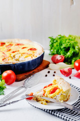 French open pie from short pastry, kish, tart with chicken, cherry tomatoes, greens and creamy cheese cress, filling, sauce and spices, pepper, lettuce and salt on white rustic background