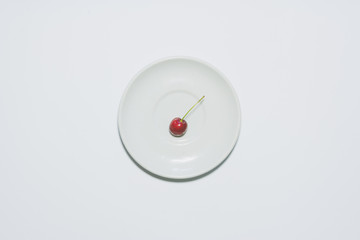 Minimal cherry background. Fruit on white plate.