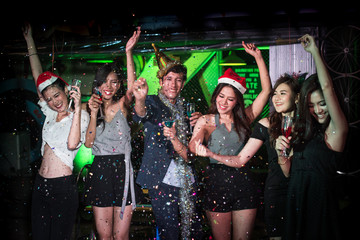 Group of asian people dancing and throwing paper together with party at nightclub, people with...