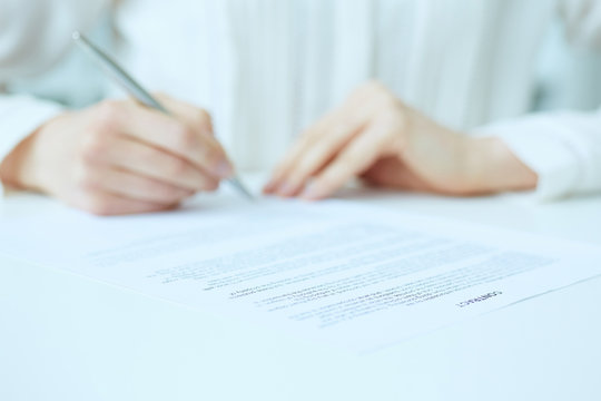 Businesswoman hands sign contract on desk. Female entrepreneur puts signature on official agreement. Profitable deal concept. Business partner accepts conditions. Focus on contract, close up