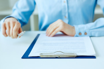 Hands of business woman signing the contract document with pen on desk. selective focus image on sign a contract.