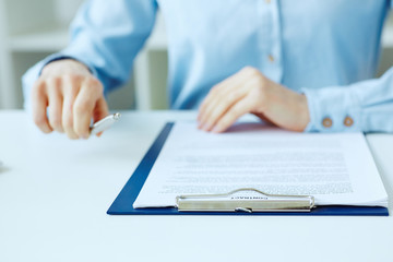 Hands of business woman signing the contract document with pen on desk. selective focus image on sign a contract.