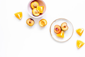tropical fruits design with orange and peach on plate white background top view mock up