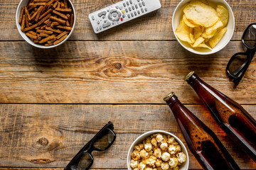 cinema and TV whatching with beer, crumbs, chips and pop corn wooden background top view mock-up