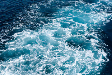 Fototapeta na wymiar Natural background of blue-green sea water with foam and waves.