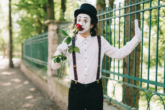 Emotional male mime artist with red rose performing love on a outdoor.