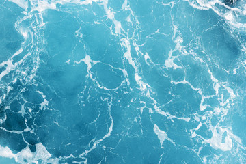 Natural background of blue-green sea water with foam