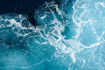 Natural background of blue-green sea water with foam