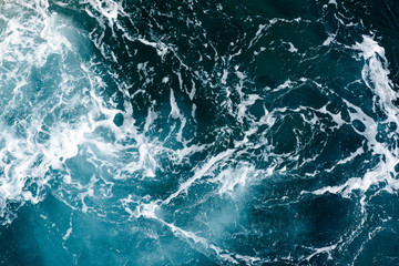 Natural background of blue-green sea water with foam