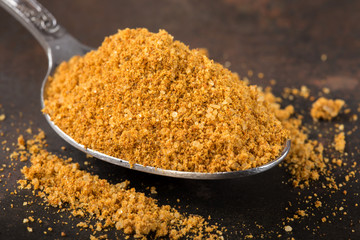 Spoon filled with spices for the preparation of roast