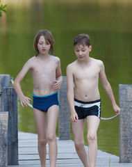 Obraz premium Two Boys Walking on Jetty