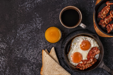 Breakfast with bacon , fried egg, coffee and orange juice.