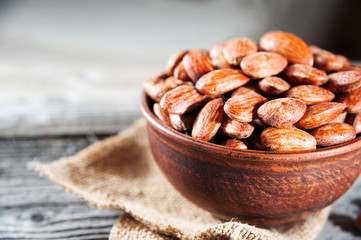 roasted almonds in bowl on wooden table