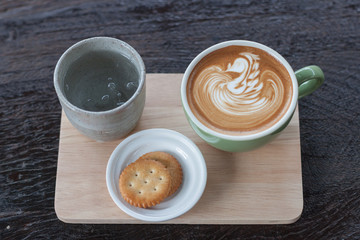 hot coffee latte on wood plate.