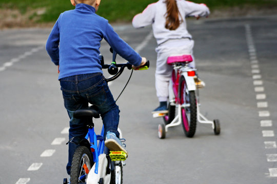 The kids compete on bicycles.