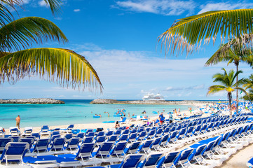 Rows of blue chairs on sea beach with white sand