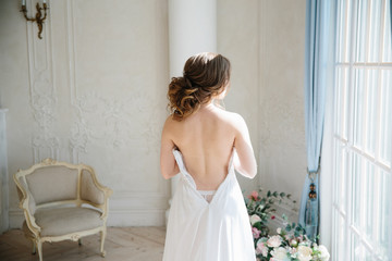 Wedding. Bride. Bride wedding Dress white lace dress standing at the window, before lacing dresses