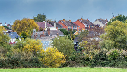 Several houses on the outskirts of the city of Exeter. Are located very close to each other. Houses with tiled and thatched roofs. Two storey houses. Autumn colorful view. Exeter. Devonshire. England