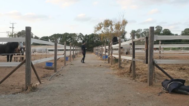 Woman walking between the stables outdoors